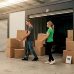 Couple carrying boxes into indoor storage unit