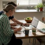 Couple comparing moving quotes at kitchen table
