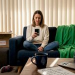 Woman researching mover reviews in her living room