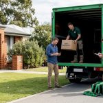 Homeowner and movers loading boxes outside house
